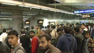 Passengers waiting as Delhi metro train arrives at station platform