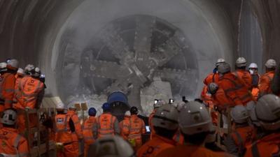 Workmen look on as tunnel machine, named Elizabeth after the Queen, to break through into the east end of Crossrail"s Liverpool Street station in London