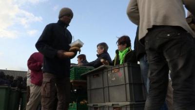 Migrants queue for food