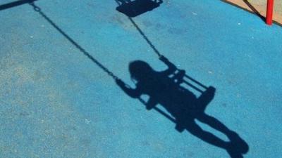 Shadow of child on swing