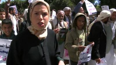 BBC reporter Sally Nabil walking alongside anti-Houthi protesters in the Yemeni capital Sanaa