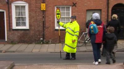 Lollipop lady Betty Ealand helping people cross the road