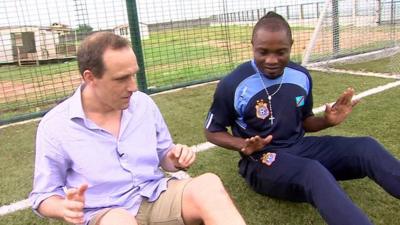 The BBC's Piers Edwards attempts to copy Kidiaba's bouncing bottom