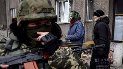 Local residents wait to board a bus to flee the conflict in Debaltseve