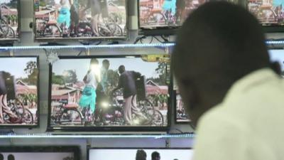 A man watches several TV screens