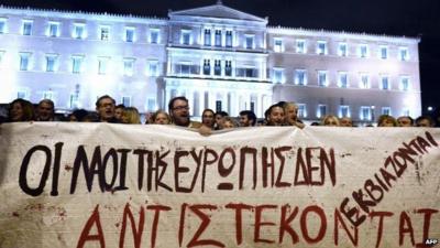 People hold a banner reading ''the people of Europe won't be blackmailed, they will resist'' in front of the Greek parliament in Athens