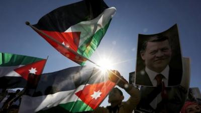Jordanian protesters hold up pictures of Jordanian King Abdullah in Amman on Thursday 5 February 2015
