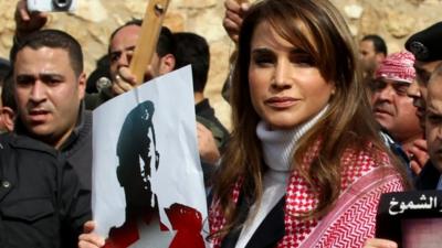 Jordanian Queen Rania holds a placard during a demonstration on February 6, 2015 in the capital Amman to express solidarity with the pilot murdered by the Islamic State