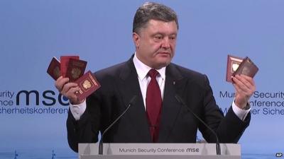 Ukraine's president Petro Poroshenko holding up six Russian passports at a conference to discuss ways to end the Ukraine conflict