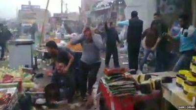 Iraqis caught up in the aftermath of an explosion outside a cinema in Baghdad