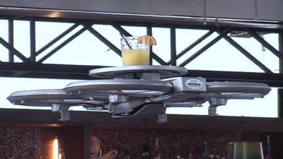 Drone waiter carries drink