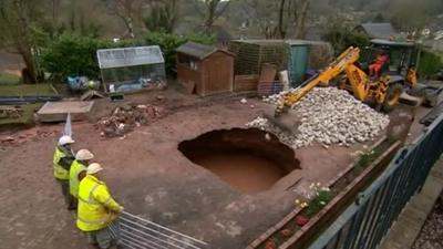 A digger filling in a hole