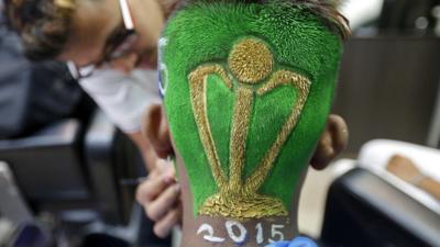 A cricket fan is pictured after having his hair trimmed into the shape of a Cricket World Cup trophy at a saloon in Mumbai, India, 12 February 2015