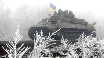 Ukrainian servicemen ride on a tank