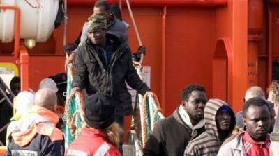 Migrants walking off boat