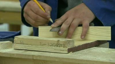 An apprentice doing woodwork