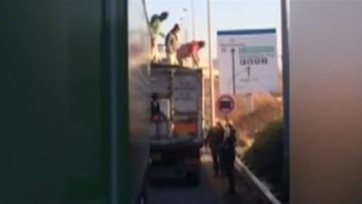 Migrants getting down off lorry