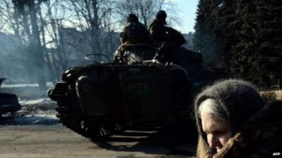 An elderly woman walks past a rebel armoured personnel carrier in the eastern Ukrainian town of Debaltseve, 20 February