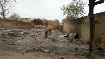 File photo of girl standing amid the burned ruins of Baga, Nigeria, following an attack by Boko Haram