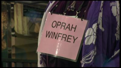 Sign around woman's neck reads 'Oprah Winfrey'