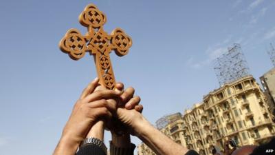 Egyptian Coptic Christians hold a cross