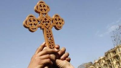 Egyptian Coptic Christians hold a cross