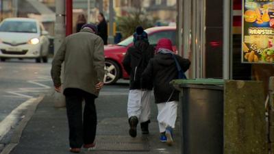 Man and children in a street in Bradford