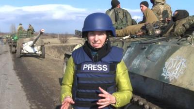BBC reporter Anastasia Gribanova standing in front of Ukrainian army vehicle in Artemivsk, eastern Ukraine