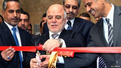 Iraq's Prime Minister Haider al-Abadi cutting a red ribbon at the re-opening of Iraq's National Museum in Baghdad