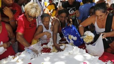 People take cake baked for an event marking the city's 450th birthday in Rio de Janeiro, Brazil