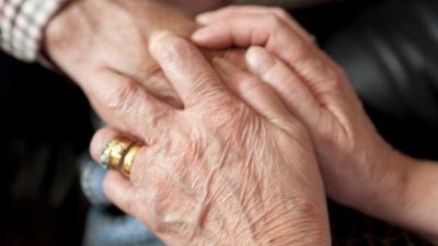 Carer holding an elderly patient's hand