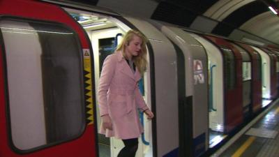 Woman steps off a tube train