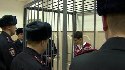 Nadiya Savchenko in a cell surrounded by Russian guards