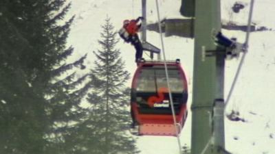 A rescue worker on top of a cable car