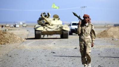 A Shi'ite fighter carries a rocket-propelled grenade launcher as he walks in the town of Hamrin in Salahuddin province