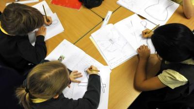 Schoolchildren drawing at their desk