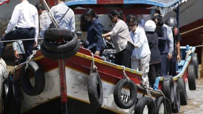 Relatives of the two condemned men disembark from a ferry after returning from a visit to the prison island of Nusakambangan