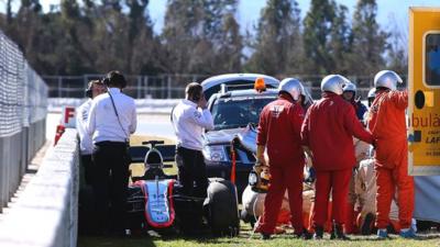 McLaren's Fernando Alonso receives medical assistance after crashing during testing in Barcelona