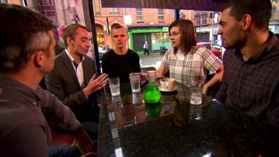 Young people in a cafe sitting around a table