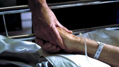 Nurse holding patient's hand