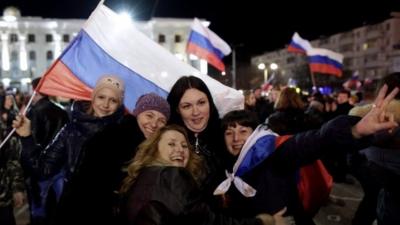 Women pose for a picture during a concert marking the one-year anniversary of Crimea voting to leave Ukraine and join the Russian state, in central Simferopol