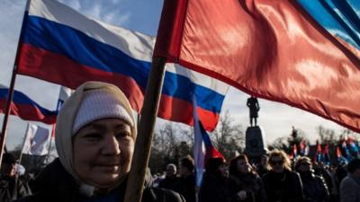 Crimeans wave Russian flags as they celebrate the first anniversary of the referendum