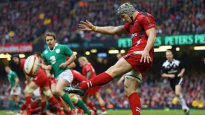 Wales' Jonathan Davies kicks the ball against Ireland