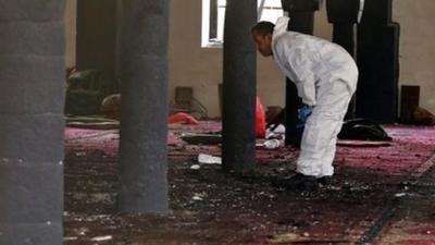 A forensic expert inspects the scene of a suicide attack targeting the al-Hashahush mosque in Sana’a