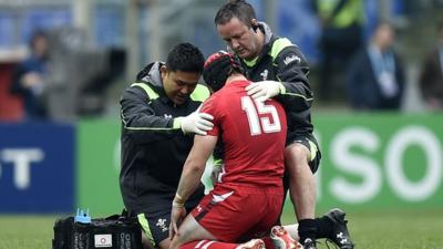 A groggy Leigh Halfpenny is assessed on the field