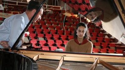 A grand piano in a bombed out concert hall in Gaza