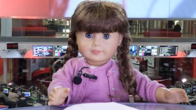 American Girl doll reading the news