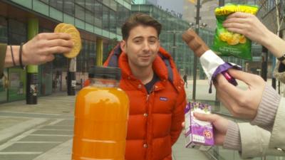 Ricky Boleto surrounded by biscuits, fruit juice, crisps and chocolate bar