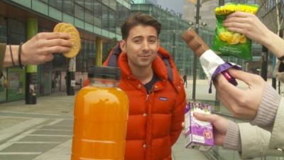 Ricky Boleto surrounded by biscuits, fruit juice, crisps and chocolate bar