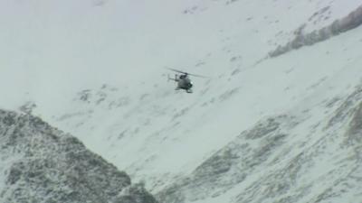 A helicopter flying through a valley